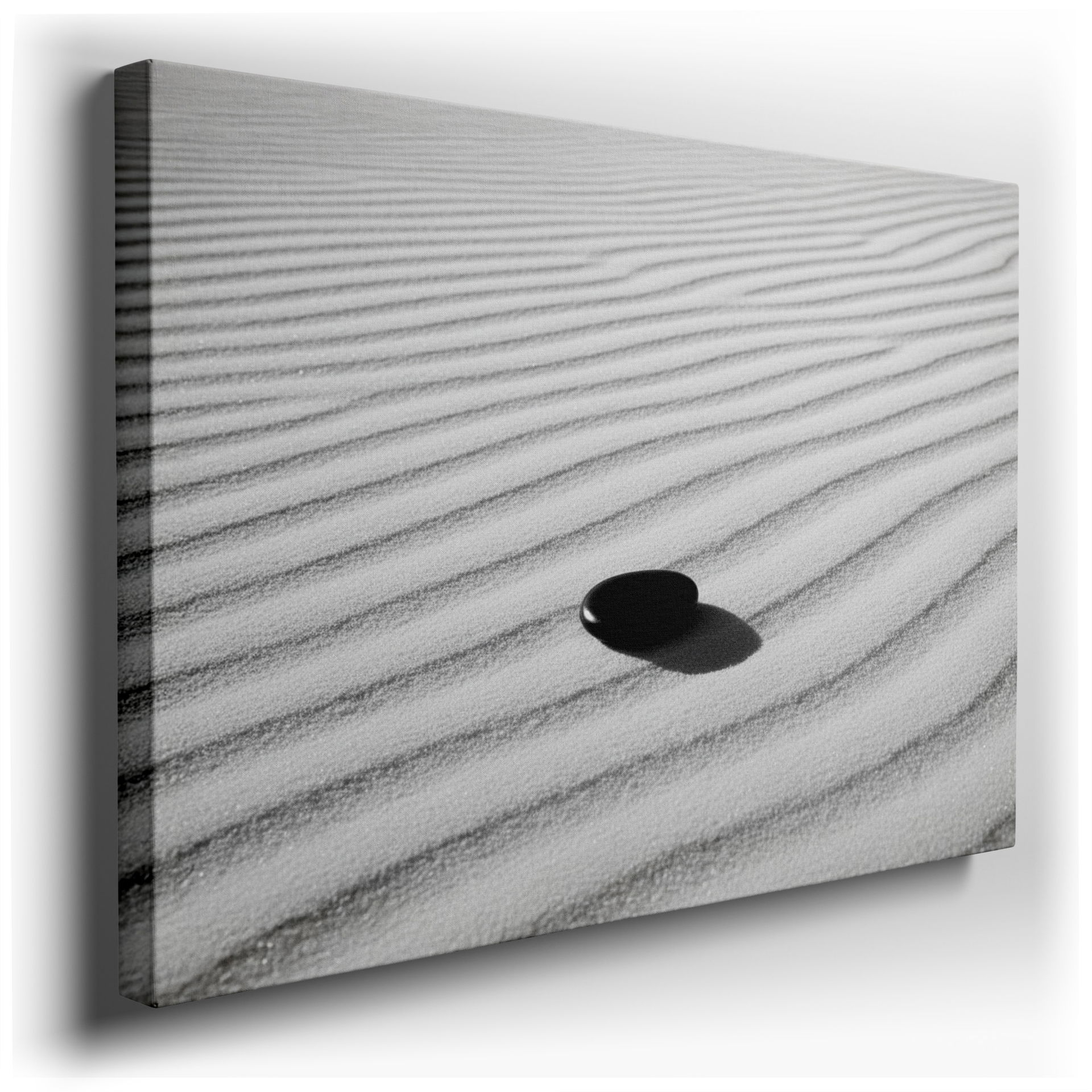 A dark zen stone casts a shadow on white sand, creating a rhythmic, minimalist wall art.