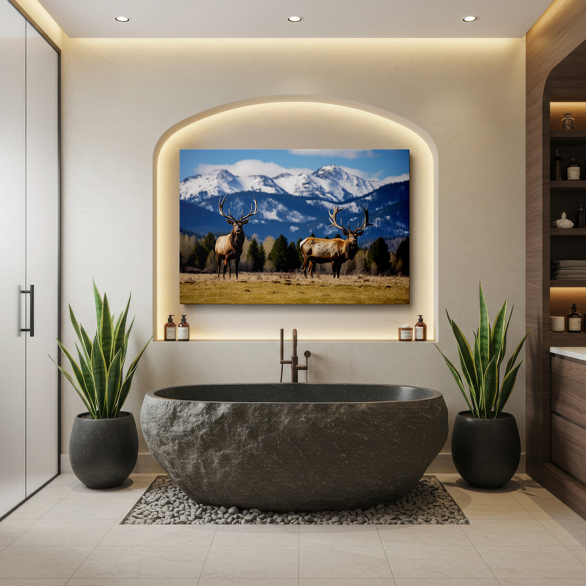 Balanced between two tall indoor plants near a window — majestic elk in expansive grassy field with snow-capped mountains panoramic large wall art, canvas wall decor for office and bedroom